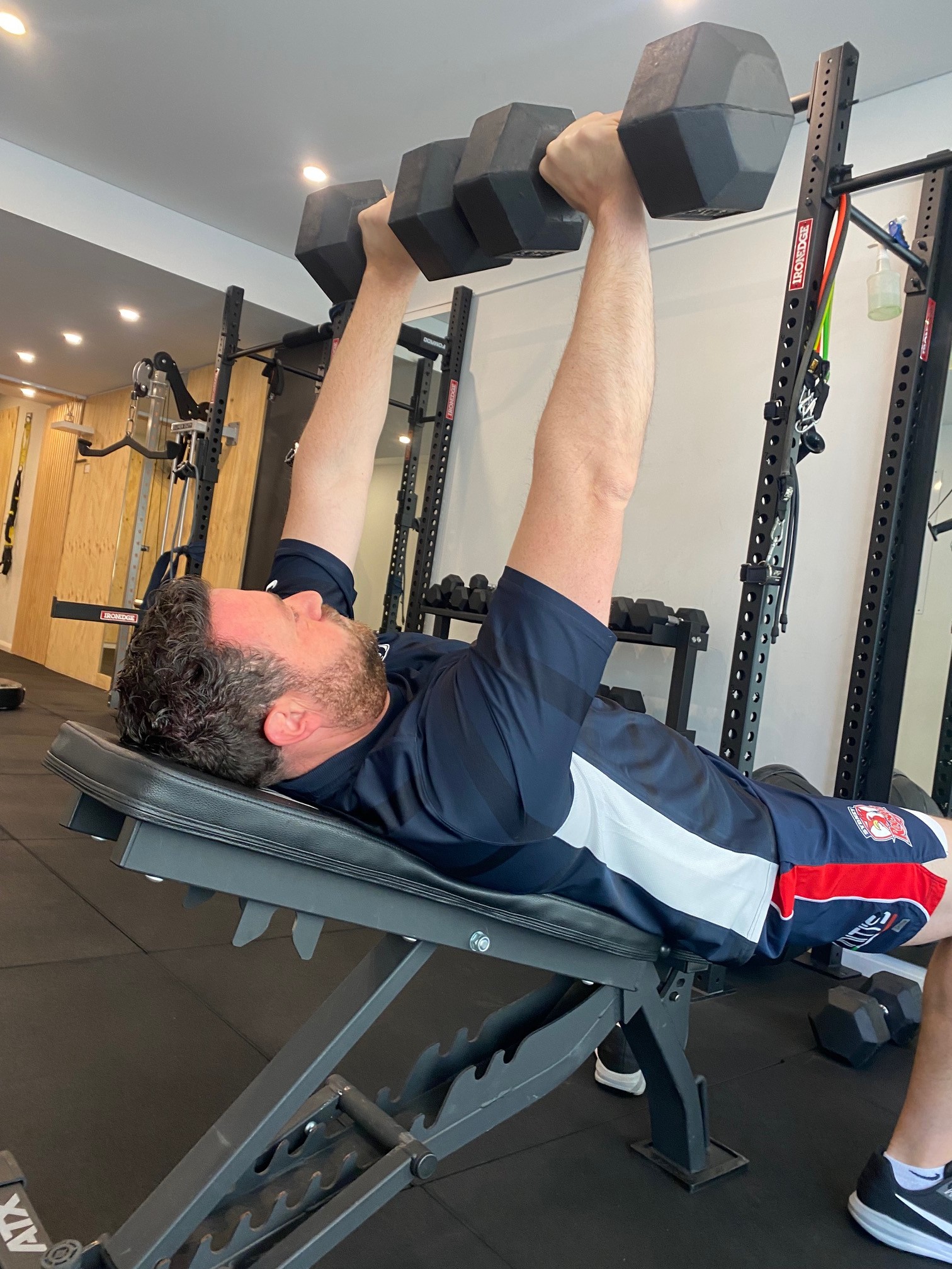 Dumbbell press at The Fitness Space studio, Maroubra Man doing a dumbbell chest press on a bench at The Fitness Space studio in Maroubra.